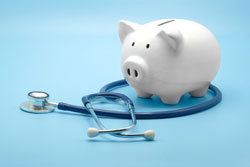 Stethoscope near a piggy bank.