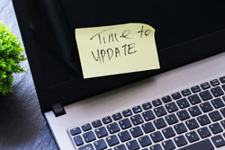 Screen of a notebook with a post-it pasted with the message time to update.